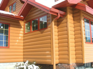 Exterior of home with large white-frame windows and orange seamless metal siding.